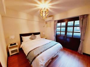 台北的住宿－陽明溫泉度假村，一间卧室配有一张大床和一个吊灯。