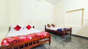 um quarto com 2 camas com almofadas vermelhas e uma janela em Kurumbalakotta Village Homestay em Padinjarathara