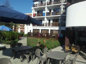 un patio con mesas y sillas frente a un edificio en Villa Mare en Sunny Beach