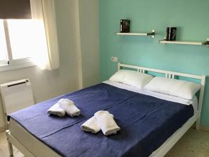 una camera da letto con un letto e due asciugamani di Apartamento Tobias, muy cerca de la playa centro a Villajoyosa