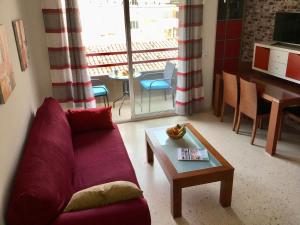 sala de estar con sofá púrpura y mesa en Apartamento Tobias, muy cerca de la playa centro, en Villajoyosa