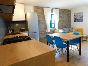 a kitchen and living room with a table and blue chairs at House Monika&Stela in Krvavica