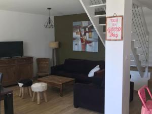 ein Wohnzimmer mit einem blauen Sofa und einem Tisch in der Unterkunft Maison familiale au cœur du Lot in Lanzac