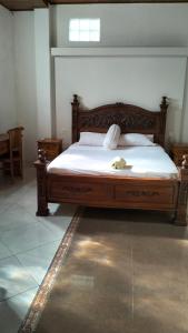 a bedroom with a large bed with a wooden frame at Uma Pejeng in Ubud