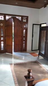 a room with a bed and wooden doors and a table at Uma Pejeng in Ubud