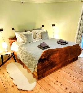 a bedroom with a large bed with two towels on it at Treehouse in Devon - 2 bedrooms in Beaworthy