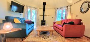 a living room with two couches and a table at Treehouse in Devon - 2 bedrooms in Beaworthy