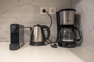 a counter top with a blender and a coffee maker at Coastal Getaway: Roomy Beachside Apartment! in Nea Makri