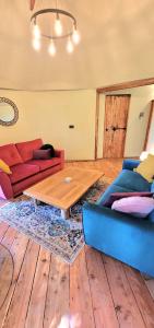 a living room with a couch and a table at Treehouse in Devon - 2 bedrooms in Beaworthy