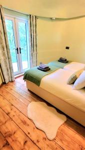 a bedroom with two beds and a large window at Treehouse in Devon - 2 bedrooms in Beaworthy