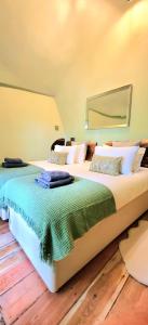 two beds in a room with a large bed at Treehouse in Devon - 2 bedrooms in Beaworthy