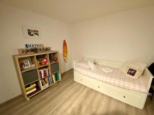 a small bedroom with a bed and a book shelf at Beau duplex à 2 min du RER B in Sevran