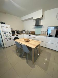 a kitchen with a wooden table and two chairs at Beau duplex à 2 min du RER B in Sevran