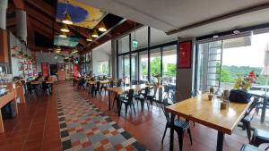 un restaurante con mesas y sillas de madera y ventanas en Yanmin Hot Spring Resort en Taipéi