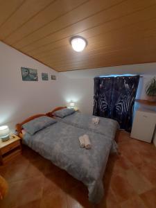 ein Schlafzimmer mit einem großen Bett und Hausschuhen darauf in der Unterkunft Ranch Radin in Brtonigla