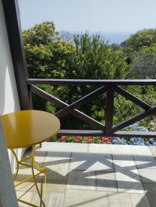 una mesa y una silla en un balcón con flores en Dimosthenis Karastamatis Rooms, en Xorychti
