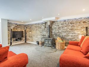 - un salon avec un mur en pierre dans l'établissement The Forge, à Llanfair Clydogau