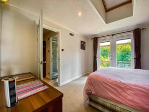 a bedroom with a bed and a table and a window at West View in Bleadon
