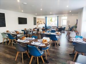 un comedor con mesas y sillas y una pizarra en La Côte de Lumière en La Tranche-sur-Mer