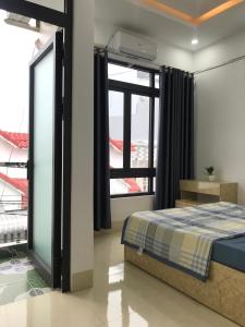 um quarto com uma cama e uma grande janela em HO GIA AN Home - Căn hộ yên bình em Can Tho