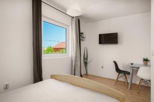 a bedroom with a bed and a window and a desk at Frida Rooms and Apartments Vodice in Vodice