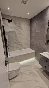 a bathroom with a white toilet and a sink at Dream apartment Finchley 4 min walk to the train in Hendon