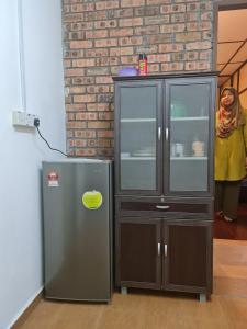 a refrigerator next to a cabinet in a room at D'Impiana Riverview Chalet # Lenggong in Kampong Ulu Jepai