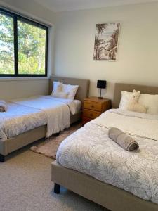 1 Schlafzimmer mit 2 Betten und einem Fenster in der Unterkunft Wanda House - Close to beach Linen Pets in Salamander Bay