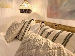 um quarto com uma cama com almofadas e um candeeiro em Esperanza 9 em Moclín