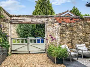 an open gate in a stone wall with a fence at Number 1 in Alnwick