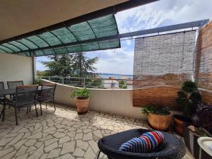 een balkon met een tafel en stoelen en uitzicht op de oceaan bij Apartments Lucija-Klara in Brodarica