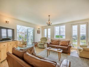 a living room with a couch and a tv at 7 Roundham Heights in Paignton