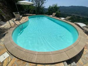 a large swimming pool with a circular coping around it at Villa Romantica Sea View in Camaiore