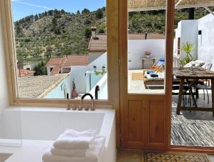 ein Badezimmer mit Badewanne und Blick auf eine Terrasse in der Unterkunft Esperanza 9 in Moclín