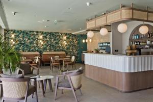 a restaurant with a bar and tables and chairs at Arcus Luxury Suites Karpathos in Karpathos