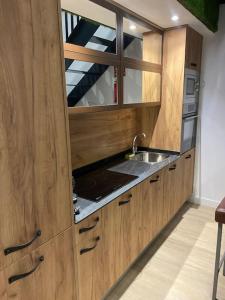 a kitchen with wooden cabinets and a sink at Moderno loft en Barajas in Madrid