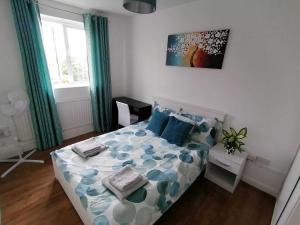 a bedroom with a bed with blue pillows at White City Apartment, your London stay in London