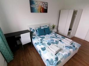 a bedroom with a bed with blue pillows and a desk at White City Apartment, your London stay in London