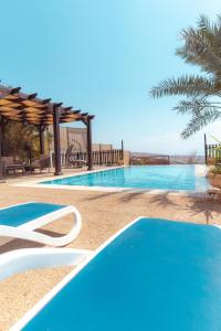 a swimming pool with blue water in a resort at Little Venice Chalet- Private Villa- Dead Sea Jordan in Sowayma