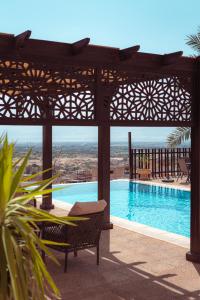 vistas a una piscina con pérgola, mesa y banco en Little Venice Chalet- Private Villa- Dead Sea Jordan, en Sowayma