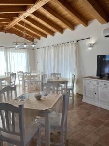 een eetkamer met tafels en stoelen en een tv bij Sa Jacca Albergo Rurale in Siniscola