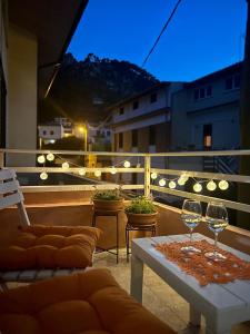 balcón con mesa y 2 copas de vino en Divina Cuspide en Guspini