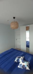 a bedroom with a bed with a blue comforter at Błękitne zacisze in Gdańsk +2 photos
