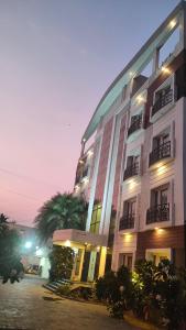 a large building with a palm tree in front of it at Pine Tree in Kanchipuram