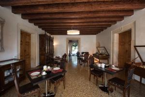 salon ze stołami i krzesłami oraz sufitem w obiekcie Villa Curti w mieście Sovizzo