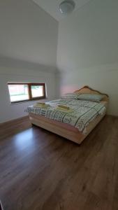 a bed in a room with a wooden floor at House_Zoi in Čelinac