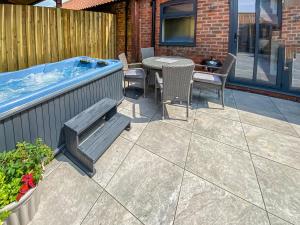 a patio with a bench and a hot tub at The Roost - Uk42856 in Rise