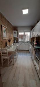 a large kitchen with a table and chairs and a stove at Apartamento COSTA VASCA Las Arenas Getxo in Getxo