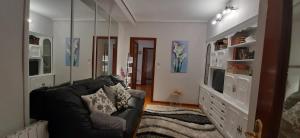 a living room with a couch and a television at Apartamento COSTA VASCA Las Arenas Getxo in Getxo