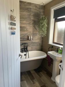 ein Badezimmer mit einer Badewanne und einem Waschbecken in der Unterkunft Southend, Mull of Kintyre, Campbeltown in Campbeltown